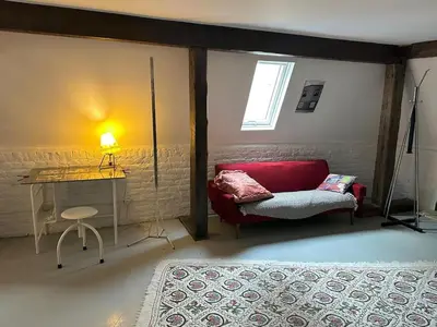 a living room with a red couch and a desk at Artist Home Private loft in Brussels