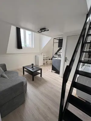 a living room with a couch and a spiral staircase at Duplex near Brussels Airport with washing machine in Vilvoorde