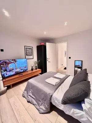 a bedroom with a large bed and a flat screen tv at European Quarter Studio in Brussels