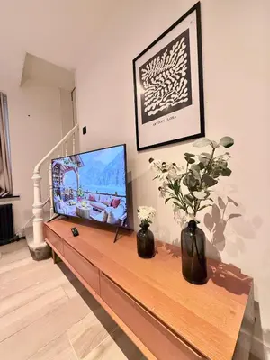 a living room with a television on a table at European Quarter Studio in Brussels