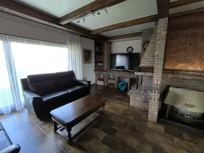 a living room with a couch and a fireplace at Willa Sunny Garden in Sint-Laureins