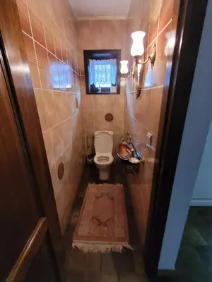 a bathroom with a toilet and a tv on the wall at Willa Sunny Garden in Sint-Laureins