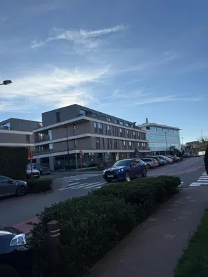 a parking lot with cars parked in front of a building at Calm & Stylish Apartment Atomium Area Bruxelles in Wemmel