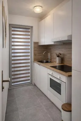 a kitchen with white cabinets and a sink at Calm & Stylish Apartment Atomium Area Bruxelles in Wemmel