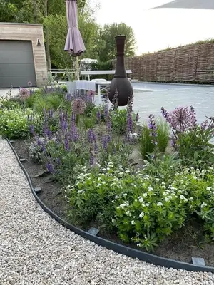 a garden with purple and white flowers and a vase at Guesthouse Dolores with Breakfast perfect for Tomorrowland Festival in Waasmunster
