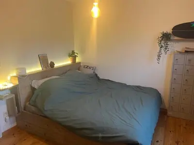 a bedroom with a bed in the corner of a room at Guesthouse Dolores with Breakfast perfect for Tomorrowland Festival in Waasmunster