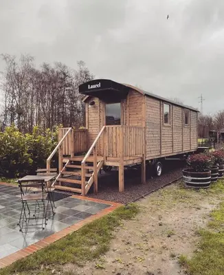 a wooden rv with a table and a table and chairs at Laurel & Hardy in Mechelen