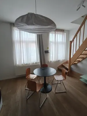 a room with a table and chairs and a staircase at Excelente localização in Brussels