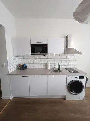 a white kitchen with a sink and a washing machine at Excelente localização in Brussels