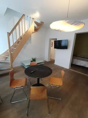 a room with a table and chairs and a staircase at Excelente localização in Brussels