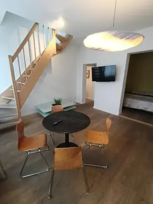 a room with a table and chairs and a staircase at Excelente localização in Brussels