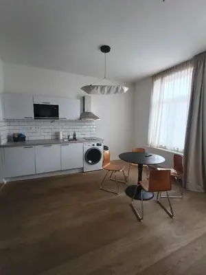 a kitchen with a table and chairs in a room at Excelente localização in Brussels