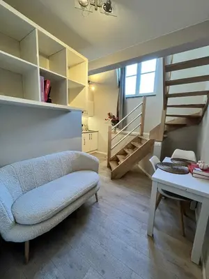 a living room with a couch and a stair case at sint-pietersplein duplex 9 in Ghent