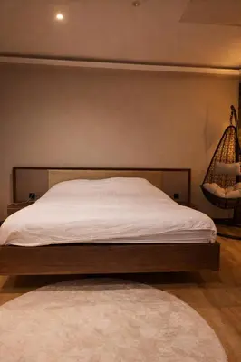 a bedroom with a bed with white sheets and a rug at Tomorrowland Luxury Apartment in Boom