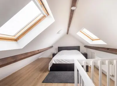 a attic bedroom with a bed and skylights at Escapade cosy Quartier EU Place Jourdan in Brussels