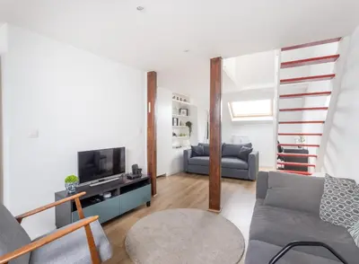 a living room with a couch and a tv at Escapade cosy Quartier EU Place Jourdan in Brussels