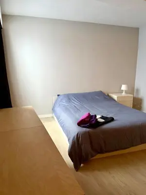 a bedroom with a bed with a purple bag on it at 3 min to the Grand-Place 6 min to Manneken Pis & Sleeps 6 in Brussels