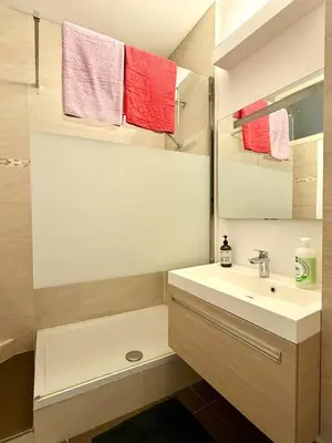 a bathroom with a sink and a mirror and towels at 3 min to the Grand-Place 6 min to Manneken Pis & Sleeps 6 in Brussels