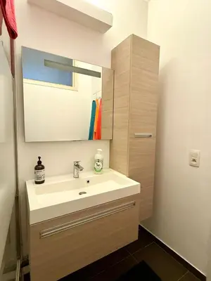 a bathroom with a sink and a mirror at 3 min to the Grand-Place 6 min to Manneken Pis & Sleeps 6 in Brussels