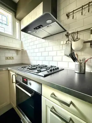 a kitchen with a stove top oven in a kitchen at 3 min to the Grand-Place 6 min to Manneken Pis & Sleeps 6 in Brussels