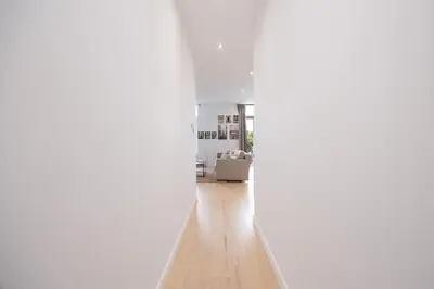 a hallway with white walls and a wooden floor at Beautiful loft in Antwerp Berchem in Antwerp
