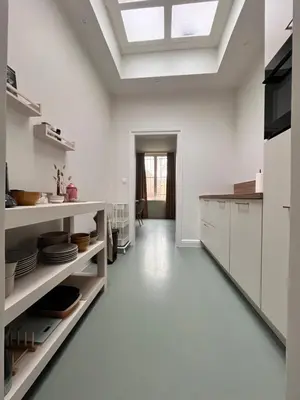 a kitchen with white cabinets and a skylight at De Durme in Temse