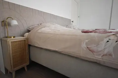 a bedroom with a bed and a lamp on a night stand at De Durme in Temse