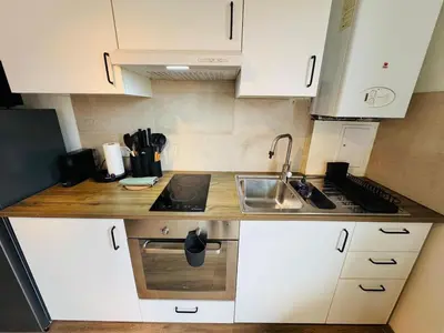a small kitchen with white cabinets and a sink at cozy apartment in Brussels in Brussels