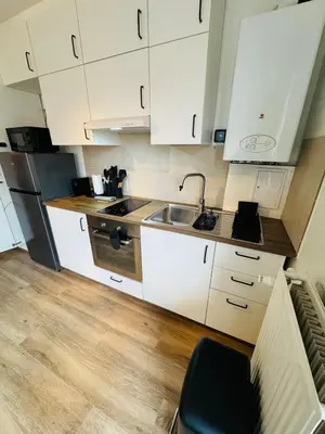 a kitchen with white cabinets and a sink at cozy apartment in Brussels in Brussels