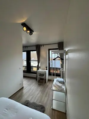 a bedroom with a bed and a desk in a room at cozy apartment in Brussels in Brussels