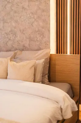 a bed with white sheets and pillows in a room at 5BR Apartment in the Heart of Ghent for Groups in Ghent