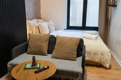 a bedroom with a bed and a table with a remote control at 5BR Apartment in the Heart of Ghent for Groups in Ghent
