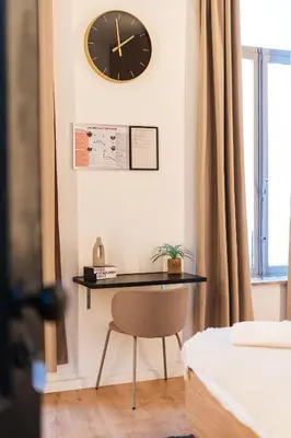 a desk with a chair and a clock on the wall at 5BR Apartment in the Heart of Ghent for Groups in Ghent