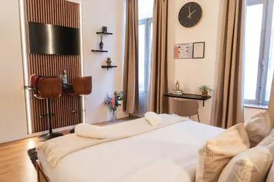 a bedroom with a bed and a clock on the wall at 5BR Apartment in the Heart of Ghent for Groups in Ghent