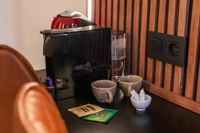 a table with cups and a coffee maker on it at 5BR Apartment in the Heart of Ghent for Groups in Ghent