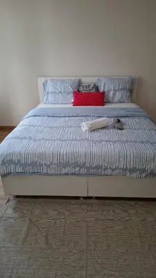 a bed with blue and white striped sheets and pillows at Chambres dans un Immeuble in Brussels