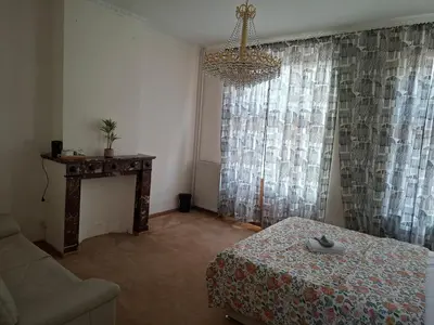 a room with a couch and a table and a chandelier at Chambres dans un Immeuble in Brussels