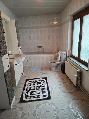 a bathroom with a tub and a toilet and a sink at Chambres dans un Immeuble in Brussels