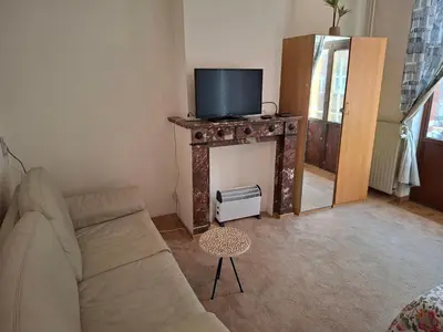 a living room with a couch and a tv on a fireplace at Chambres dans un Immeuble in Brussels