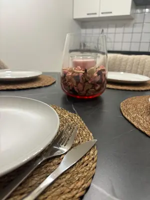 a table with plates and utensils and a glass vase at Modern 1BR and Sofa Bed Near Airport in Brussels