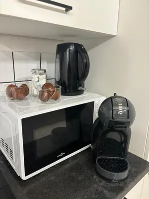 a microwave oven with a coffee maker on top of it at Modern 1BR and Sofa Bed Near Airport in Brussels