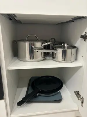 two pots and pans on a shelf in a kitchen at Modern 1BR and Sofa Bed Near Airport in Brussels