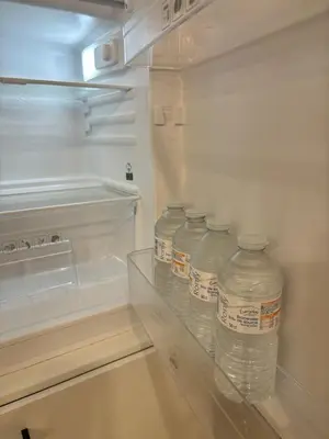 a group of water bottles sitting in an empty refrigerator at Modern 1BR and Sofa Bed Near Airport in Brussels