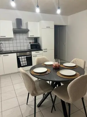 a kitchen with a black table and chairs in a kitchen at Modern 1BR and Sofa Bed Near Airport in Brussels