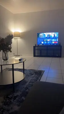 a living room with a table and a tv at Modern 1BR and Sofa Bed Near Airport in Brussels