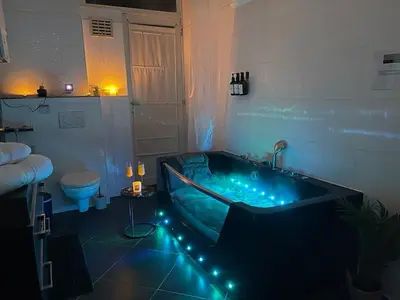 a bathroom with a blue tub with lights in it at Beautiful condominium with jacuzzi in Brussels