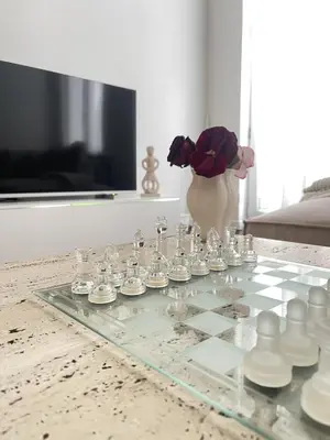 a glass chess table with a vase of flowers at Beautiful condominium with jacuzzi in Brussels