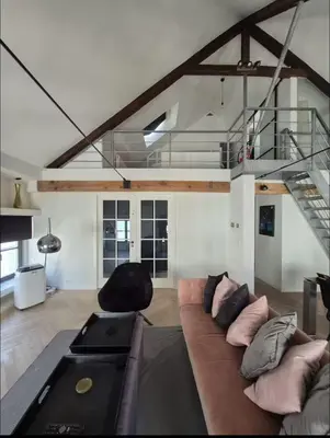 a living room with a brown couch with pillows at Chique loft uitzicht kathedraal Antwerpen in Antwerp
