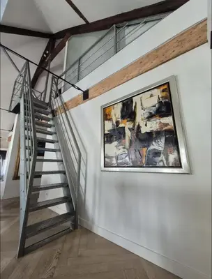 a staircase in a house with a painting on the wall at Chique loft uitzicht kathedraal Antwerpen in Antwerp