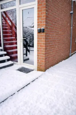 a door to a brick building with snow on the ground at Studio confortable situé à Woluwe Saint Lambert in Brussels